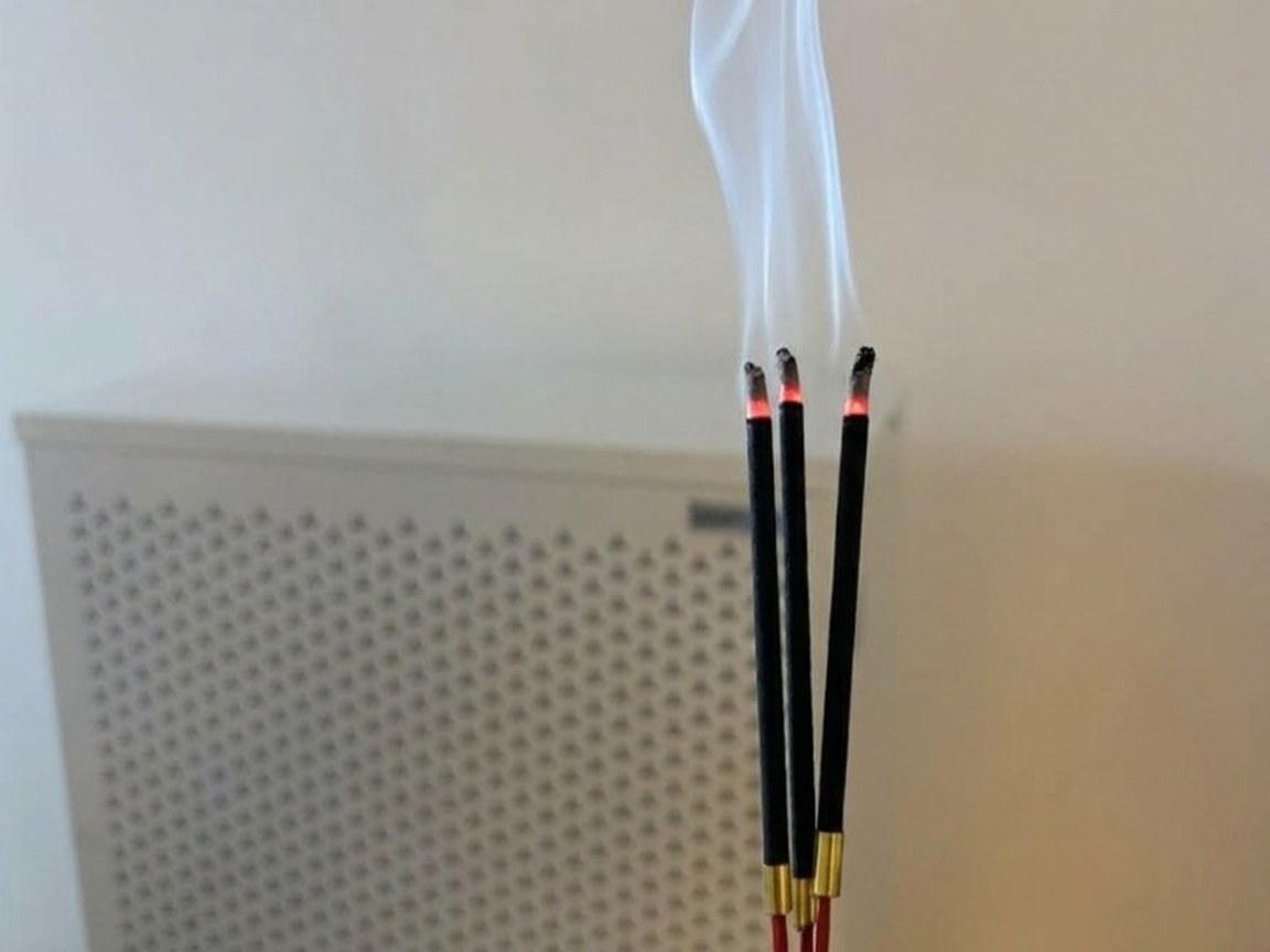 ธูปสามดอกกำลังจุดควันลอยอยู่หน้า Smart Air Blast ในห้องทดสอบของ AirLab