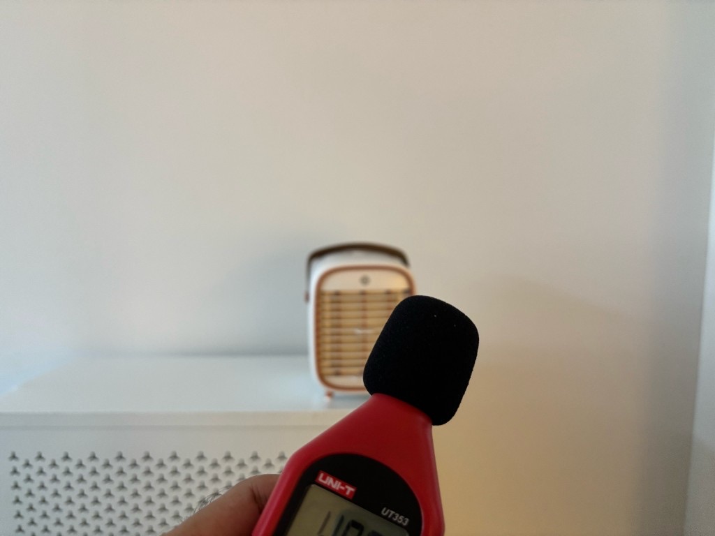 เครื่องวัดเสียง UNI-T UT353 ถือห่าง 1 ม. ด้านหน้า Smart Air QT3 บนโต๊ะสีขาว