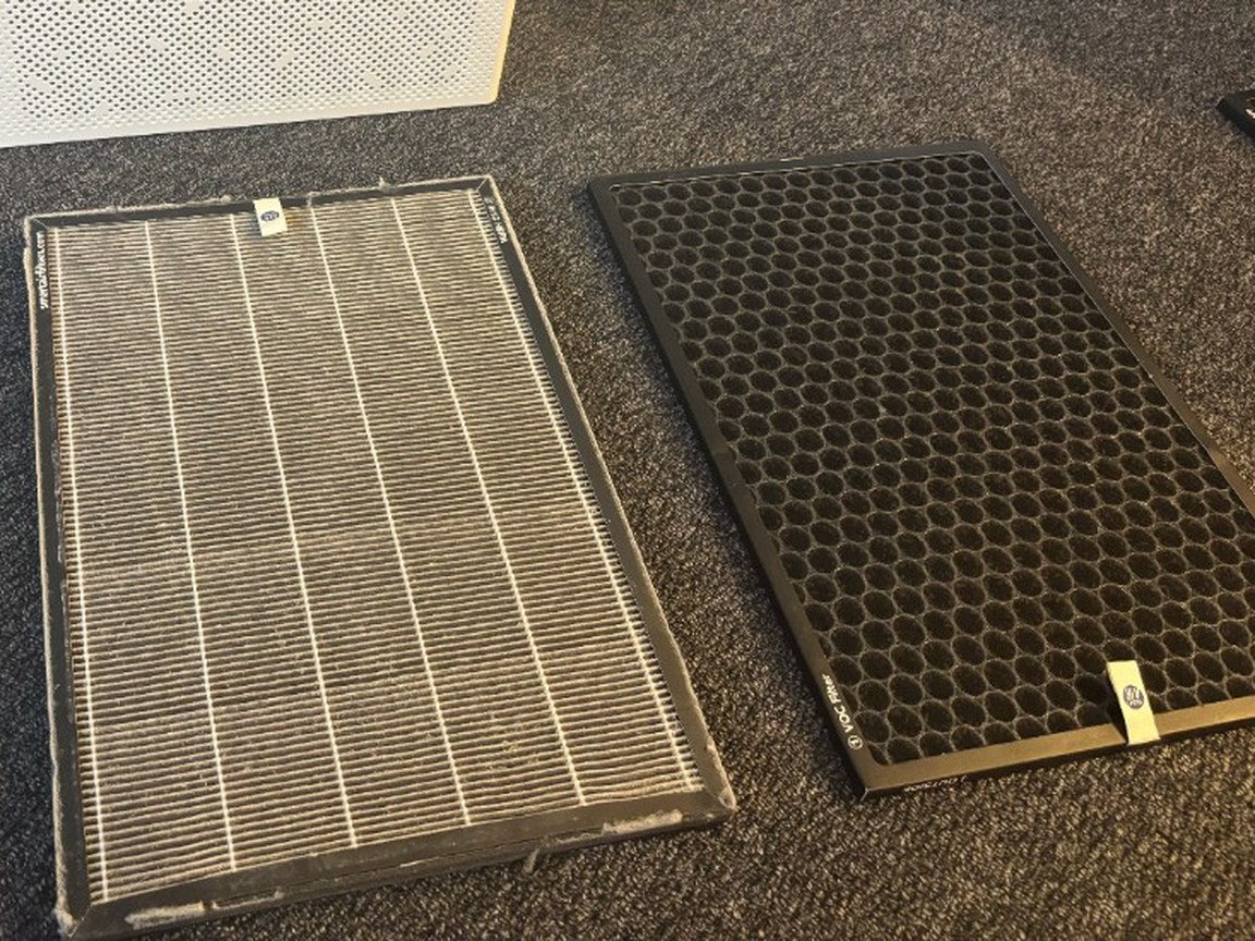 ฟิลเตอร์ H13 HEPA แบบจีบของ SA600 และฟิลเตอร์คาร์บอนแบบรังผึ้งที่มีป้าย VOC Filter วางบนพรมหน้าตัวเครื่อง